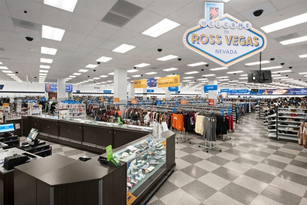 Wide view of a Ross Dress for Less store interior with clothing racks, checkout counters, and a “Welcome to Ross Vegas Nevada” sign overhead.