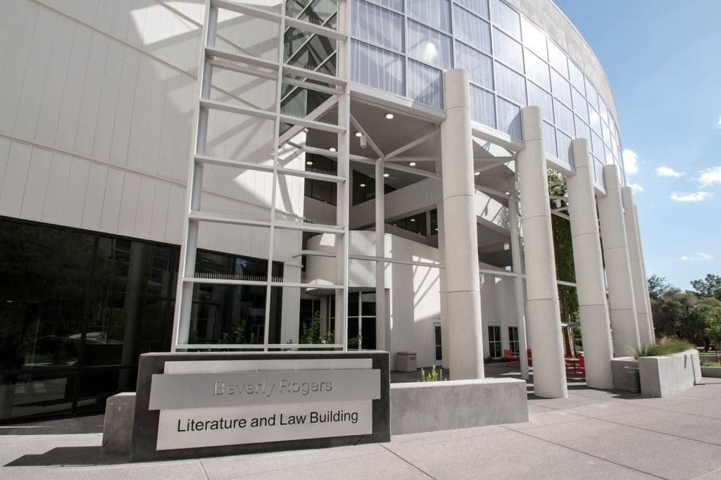 Exterior view of the Beverly Rogers Literature and Law Building with large windows and columns at the entrance.