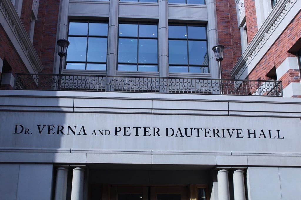 Exterior view of Dr. Verna and Peter Dauterive Hall, showing the building's name on the facade and large windows above.