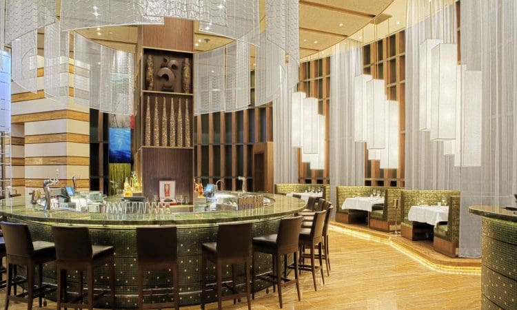Aliante Casino & Hotel interior built by PENTA with a central circular bar surrounded by black chairs, decorative lighting, and private booth seating along the walls.