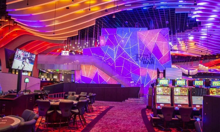 Desert Diamond West Valley Casino interior construction by PENTA featuring slot machines, gaming tables, vibrant lighting, and a large illuminated sign for "The Rock Bar" on a geometric wall.