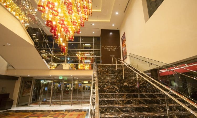 Marble staircase with glass railings leads to the Golden Nugget Conference Center; modern lighting fixtures hang from the ceiling in a spacious lobby.