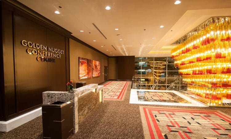 Lobby area of the Golden Nugget Conference Center with decorative lighting, a reception desk, and abstract artwork on the wall.
