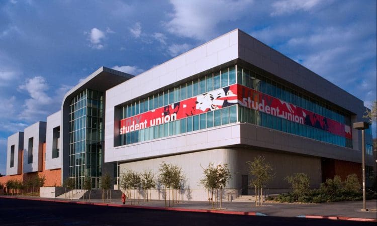 A modern building labeled "student union" with large windows, a red and white banner, and a small landscaped area in front.
