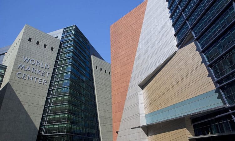 Glass and concrete buildings of the World Market Center with sharp angles and geometric patterns under a clear blue sky.